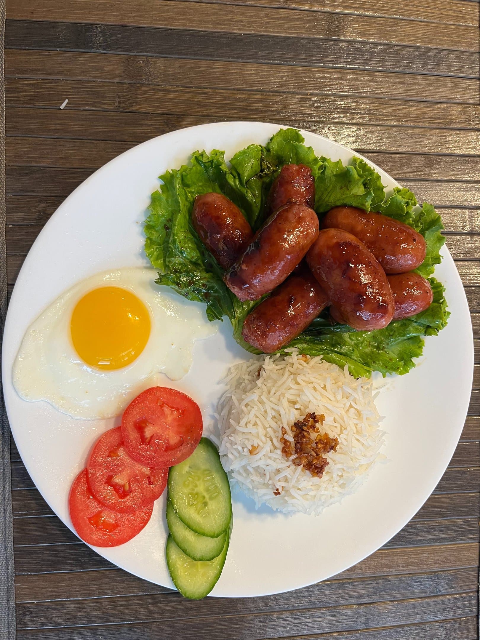 Sweet chorizo with garlic rice, fried egg, tomato and cucumber